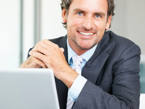 Man Smiling behind his laptop